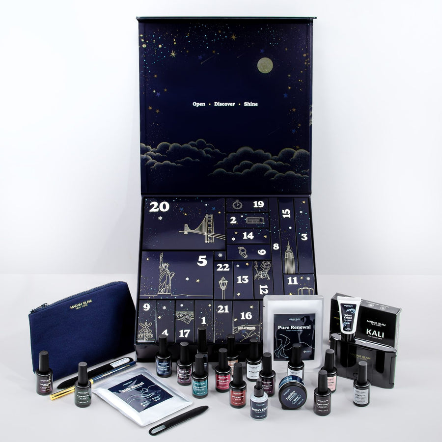 The Madam Glam 2026 Advent Calendar open, with all 25 products laid out in front: gel polishes, the KALI mini lamp, hand butter, massage candle, files and a pouch